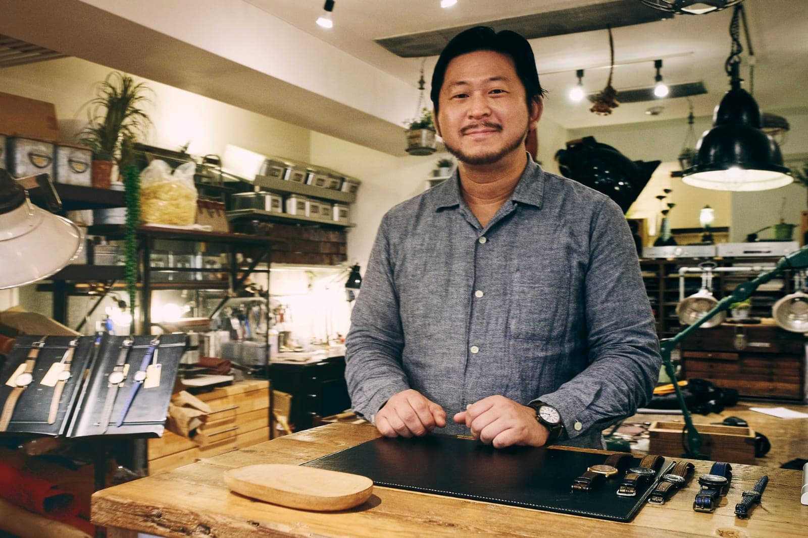 A shop owner standing behind the counter of his workshop